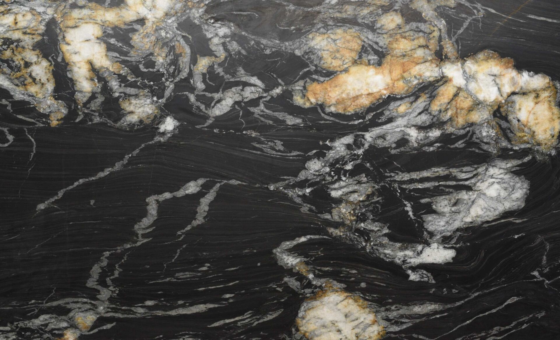 Ardesia Fume honed black slate slab close up, with rust gold veining